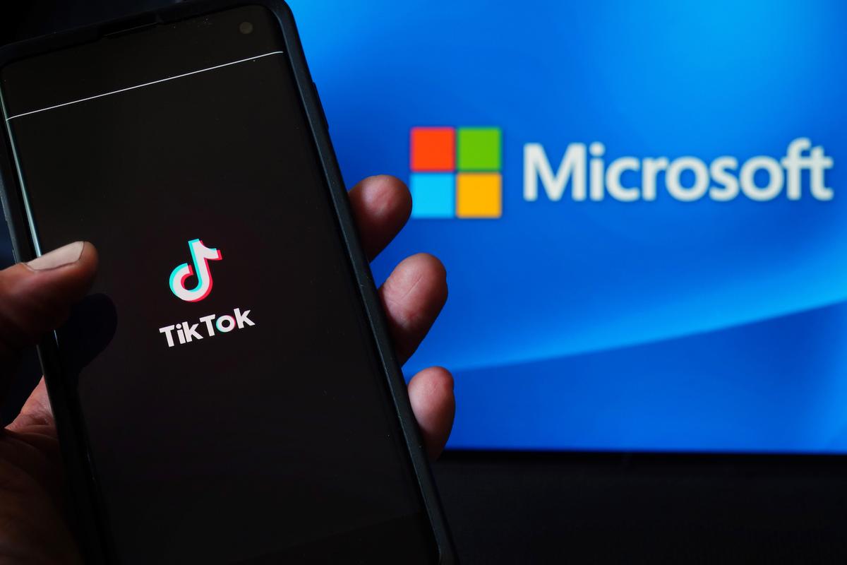 In this photo illustration, a mobile phone featuring the TikTok app is displayed next to the Microsoft logo in New York City on Aug. 3, 2020. (Cindy Ord/Getty Images)