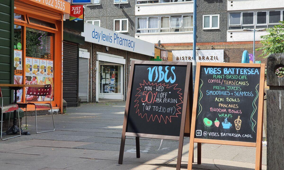 A sign advertising a 50 percent discount beside the café's menu outside Vibes café, in Battersea, London, Britain, on Aug. 3, 2020. (Lily Zhou/The Epoch Times)