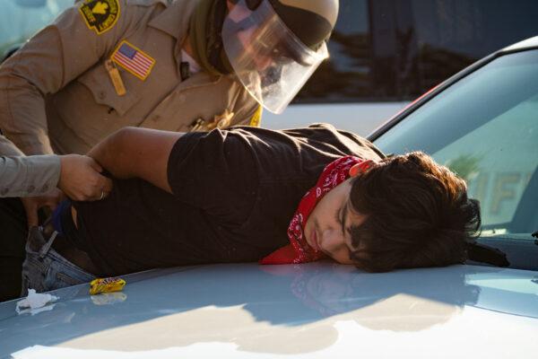 A protester is arrested in Yucaipa, Calif., on Aug. 1, 2020. (John Fredricks/The Epoch Times)