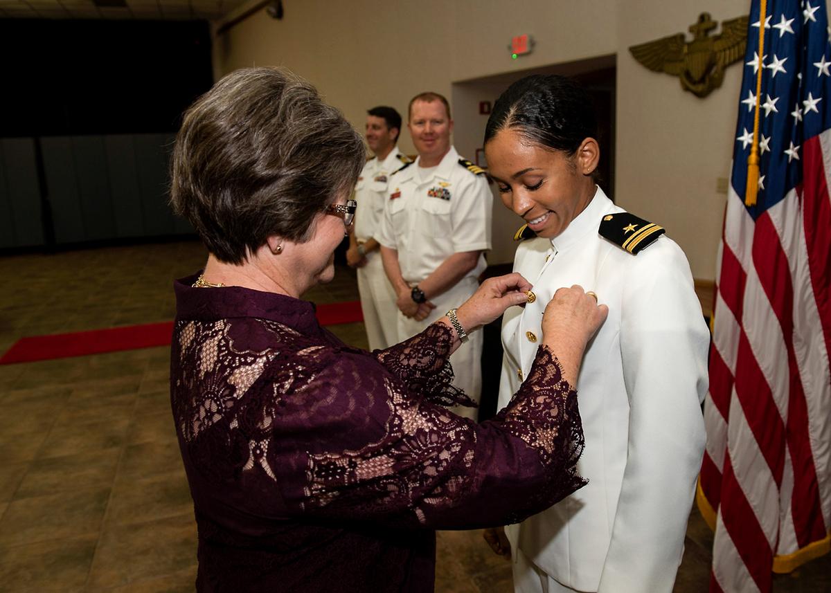 Lt. j.g. Madeline Swegle receives her naval aviator Wings of Gold from her friend Barbara Dodson during a ceremony aboard Naval Air Station Kingsville. (Anne Owens/U.S. Navy)