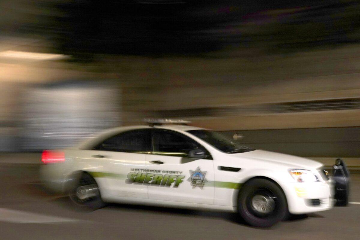 A Multnomah County Sheriff's Office cruiser drives past the Mark O. Hatfield U.S. Courthouse during a Black Lives Matter protest in Portland, Ore., early Aug. 3, 2020. (Nathan Howard/Getty Images)