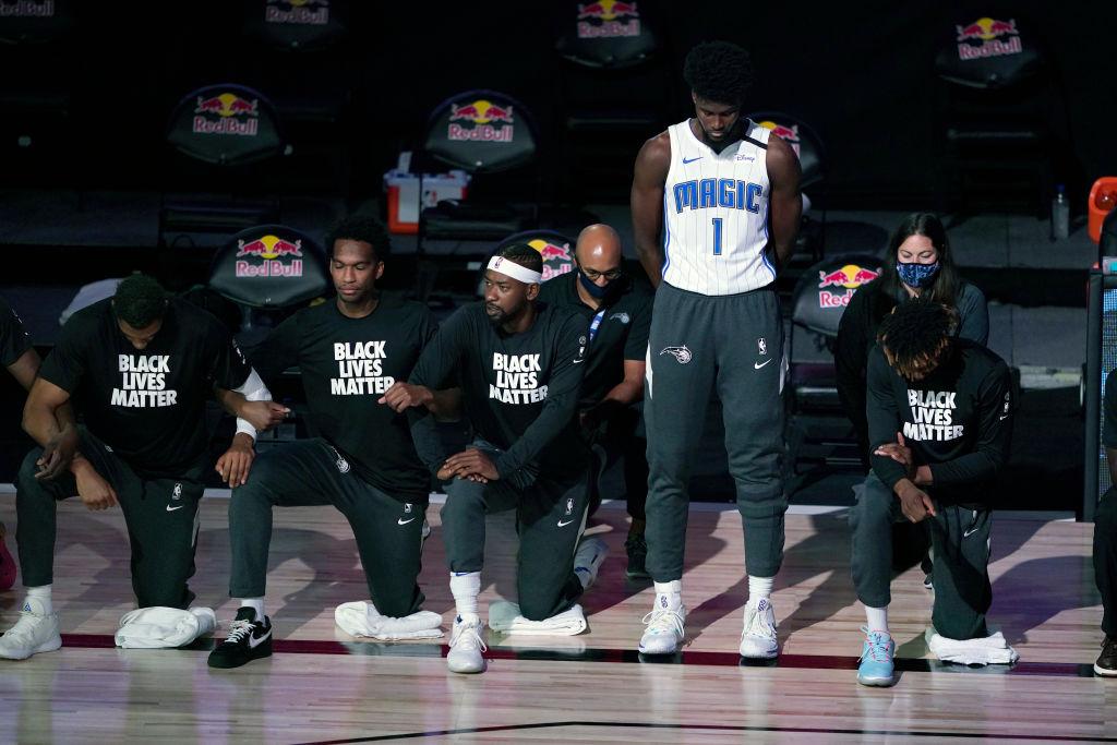 Orlando Magic’s Jonathan Isaac stands as others kneel before the start of an NBA basketball game between the Brooklyn Nets and the Orlando Magic Friday in Lake Buena Vista, Fla. on July 31, 2020. (Ashley Landis - Pool/Getty Images)
