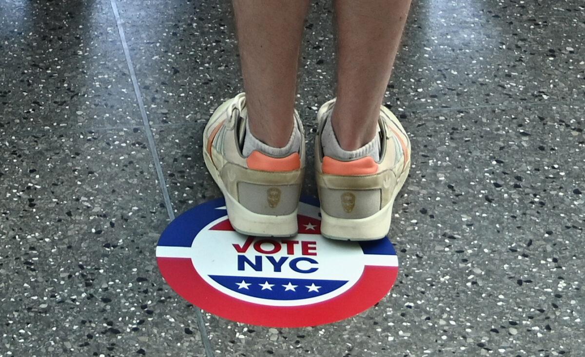 A voter stands on a Vote NYC sticker to encourage social distancing during the New York Democratic presidential primary elections in New York City on June 23, 2020. (Angela Weiss/AFP via Getty Images)
