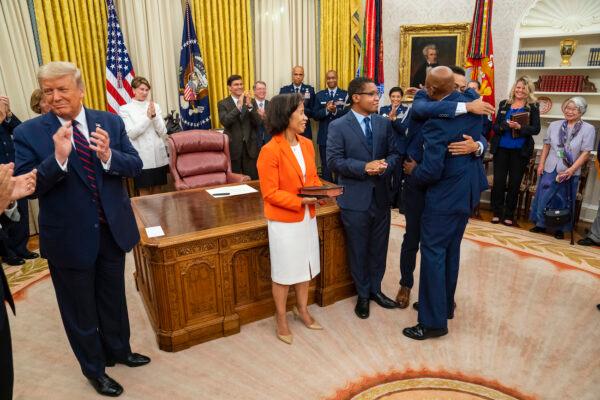 Gen. Charles Q. Brown embraces family members after being sworn in as the incoming chief of staff of the Air Force as U.S. President Donald Trump and Vice President Mike Pence look on, in the Oval Office of the White House on Aug. 4, 2020. (Doug Mills-Pool/Getty Images)