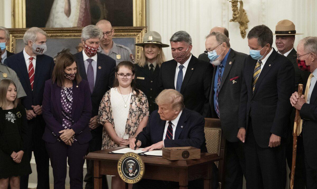 President Donald Trump signs the Great American Outdoors Act during a singing ceremony in the East Room of the White House on Aug. 4, 2020. (Drew Angerer/Getty Images)