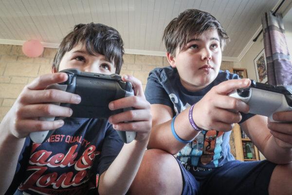 Two boys playing with an XBox game console in Vezin on Thursday 26 March 2020. (Bruno Fahy/Belga Mag/AFP via Getty Images)