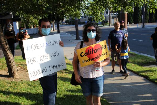 Parents hold signs calling for the reopening of schools at a protest in front of the Santa Ana Educators Association building in Santa Ana, Calif., on Aug. 4, 2020. (Jamie Joseph/The Epoch Times)