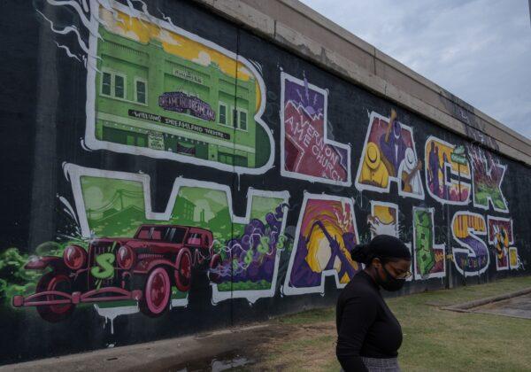 A woman walks past a "Black Wall Street" mural during Juneteenth celebrations in the Greenwood district of Tulsa, the site of the 1921 race massacre, on June 19, 2020. (Seth Herald/AFP via Getty Images)