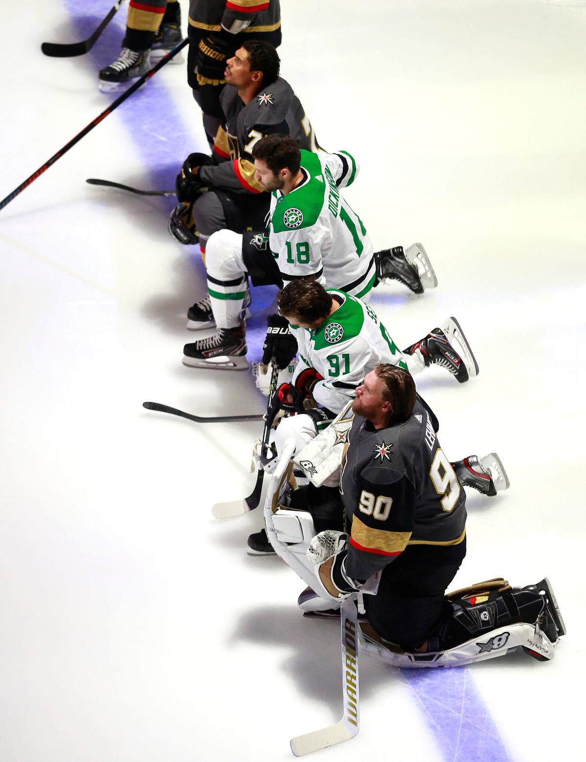 Robin Lehner and Ryan Reaves of the Vegas Golden Knights and Tyler Seguin and Jason Dickinson of the Dallas Stars kneel for the United States anthem before their Western Conference Round Robin game during the 2020 NHL Stanley Cup Playoff at Rogers Place on Aug. 3, 2020, in Edmonton. (Jeff Vinnick/Getty Images)