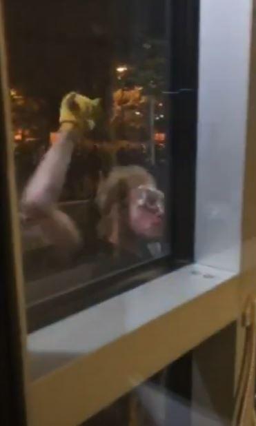 In this still image from video, a rioter uses a hammer to break glass front doors at the Portland Police Bureau's East Precinct, in Portland, Ore., on Aug. 5, 2020. (Portland Police Bureau)