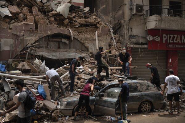 People remove debris from a house damaged by Tuesday's explosion in the seaport of Beirut, Lebanon on Aug. 7, 2020. (Felipe Dana/AP Photo)
