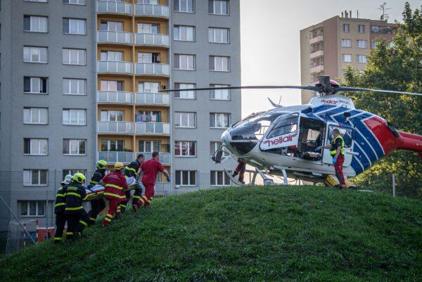Firefighters carry a stretcher to a waiting helicopter at the scene where a fire broke out in an apartment block in Bohumin, eastern Czech Republic, on Aug. 8, 2020. (Lukas Kabon/AFP via Getty Images)