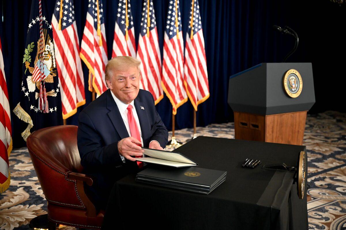 President Donald Trump signs executive orders extending coronavirus economic relief, during a news conference in Bedminster, N.J., on Aug. 8, 2020. (Jim Watson/AFP via Getty Images)