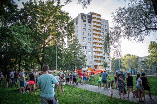 People look on as firefighters work at the scene where a fire broke out in an apartment block in Bohumin, eastern Czech Republic, on Aug. 8, 2020. (Lukas Kabon /AFP via Getty Images)