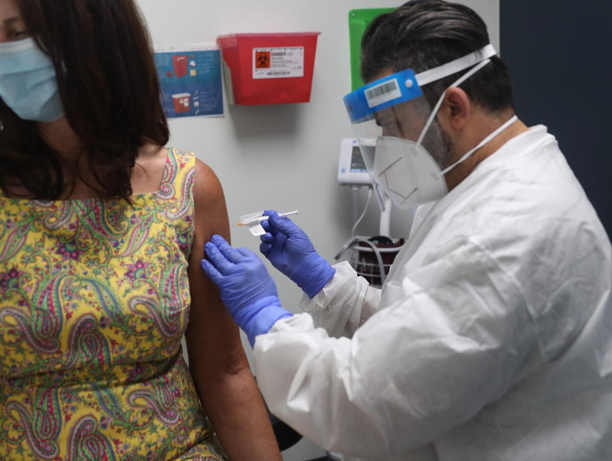 RN Jose Muniz gives a CCP virus vaccination to a volunteer at Research Centers of America in Hollywood, Fla., on Aug. 7, 2020. (Joe Raedle/Getty Images)