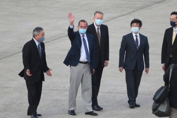U.S. Health and Human Services Secretary Alex Azar, second left, waves to media as he arrives at Taipei Songshan Airport in Taipei, Taiwan, Sunday, Aug. 9, 2020. (AP Photo/Chiang Ying-ying)