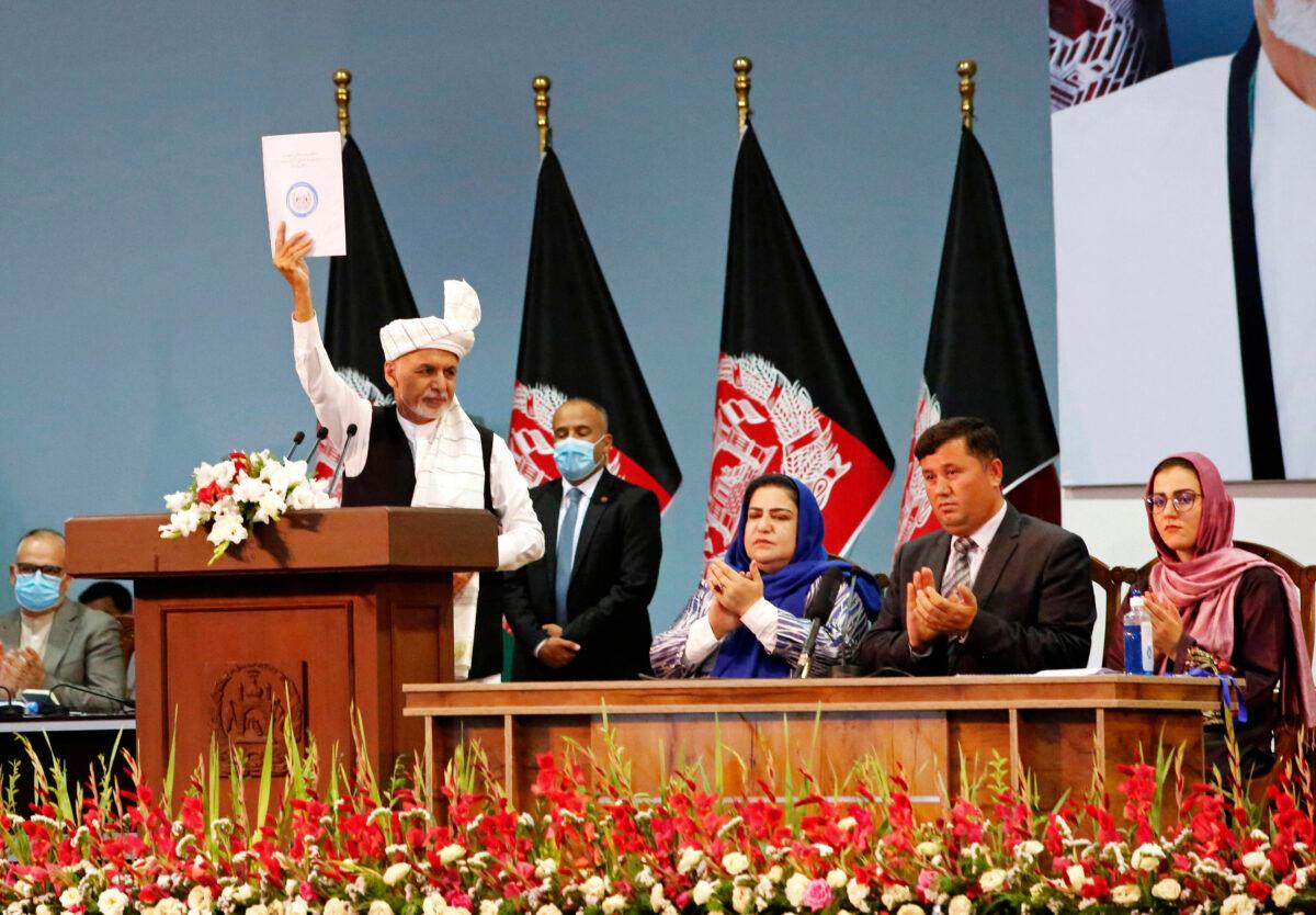 Afghan President Ashraf Ghani holds up the resolution on the last day of an Afghan Loya Jirga or traditional council, in Kabul, Afghanistan, Sunday, Aug. 9, 2020.(AP Photo)