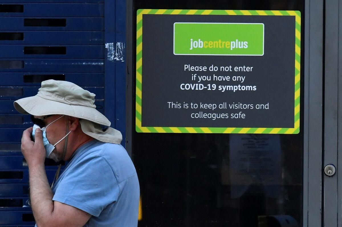 A person wearing a protective face mask walks past a Job Centre Plus office, amidst the outbreak of the CCP virus disease (COVID-19) in London, on Aug. 11, 2020. (Toby Melville/Reuters)