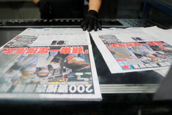 An employee checks the print quality of copies of the Apple Daily newspaper, published by Next Media Ltd, with a headline "Apple Daily will fight on" after media mogul Jimmy Lai Chee-ying, founder of Apple Daily was arrested by the national security unit, at the company's printing facility in Hong Kong, China, on Aug. 11, 2020. (Tyrone Siu/Reuters)