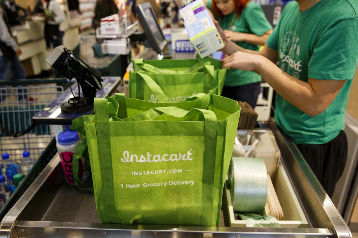 InstaCart employees fulfill orders for delivery at the new Whole Foods Market Inc. store in downtown Los Angeles, Calif., on Nov. 9, 2015. (Patrick T. Fallon/Bloomberg Photo via Getty Images)