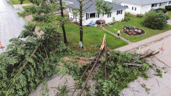 Downed trees and a utility pole in front of the home of Tim and Patricia Terres in Walcott, Iowa, after high winds and heavy rain passed through the area in Davenport, Iowa, on Aug. 10, 2020. (Kevin E. Schmidt/Quad City Times via AP)