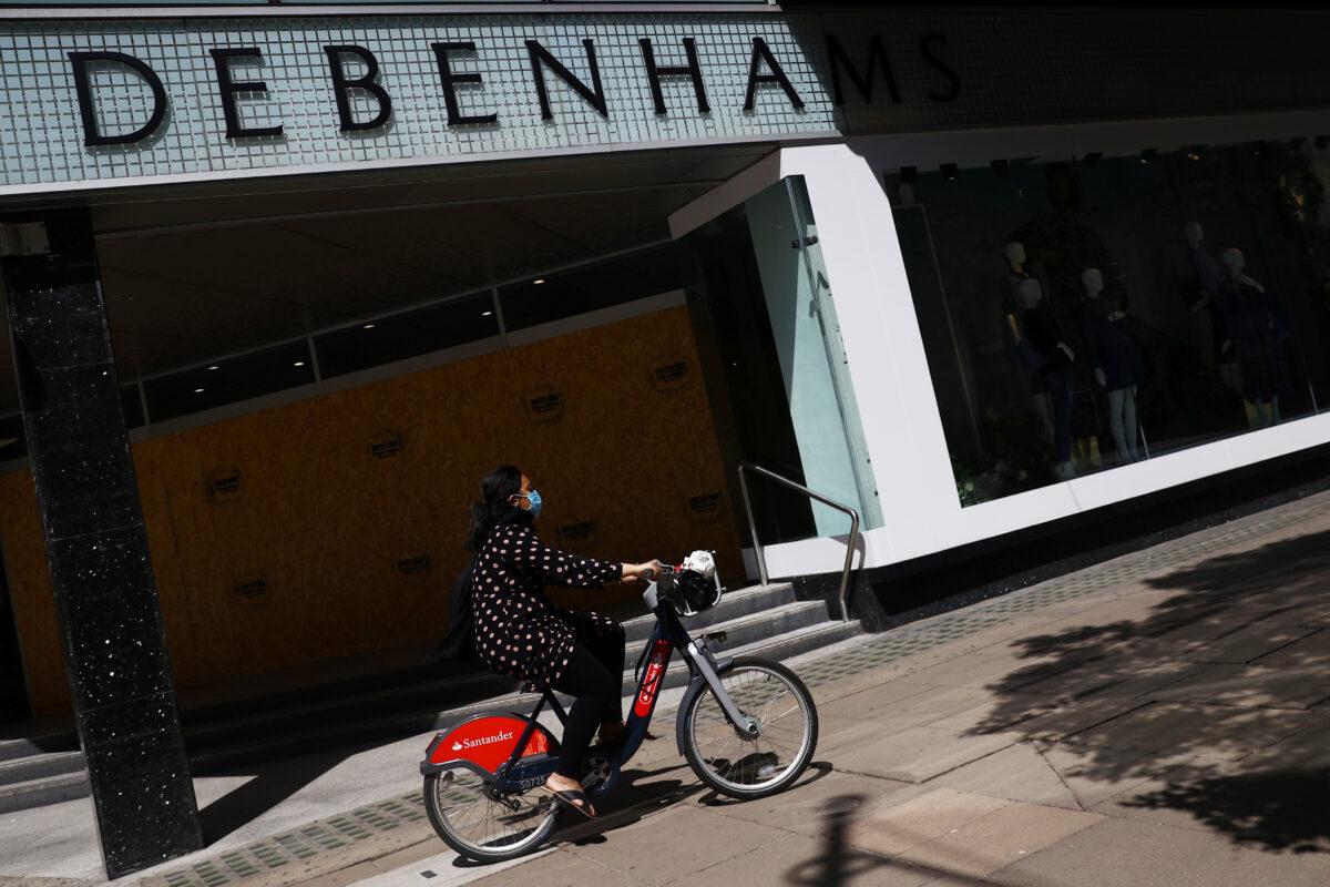 A cyclist wearing a mask goes past Debenhams in Oxford Circus, following the outbreak of the coronavirus disease (COVID-19), London, Britain, on May 28, 2020. (Hannah McKay/ Reuters)