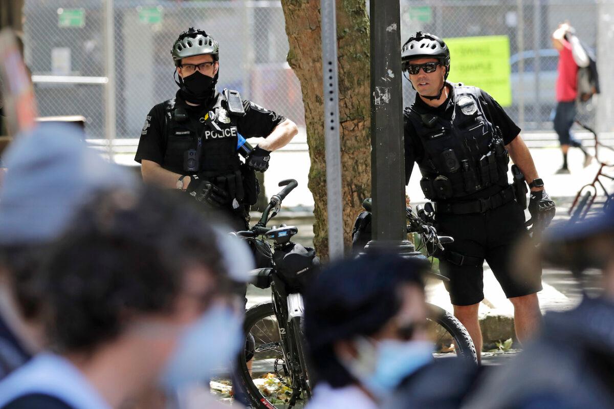 Police officers look on at protesters in Seattle, Washington, on July 20, 2020. (Elaine Thompson/AP Photo)