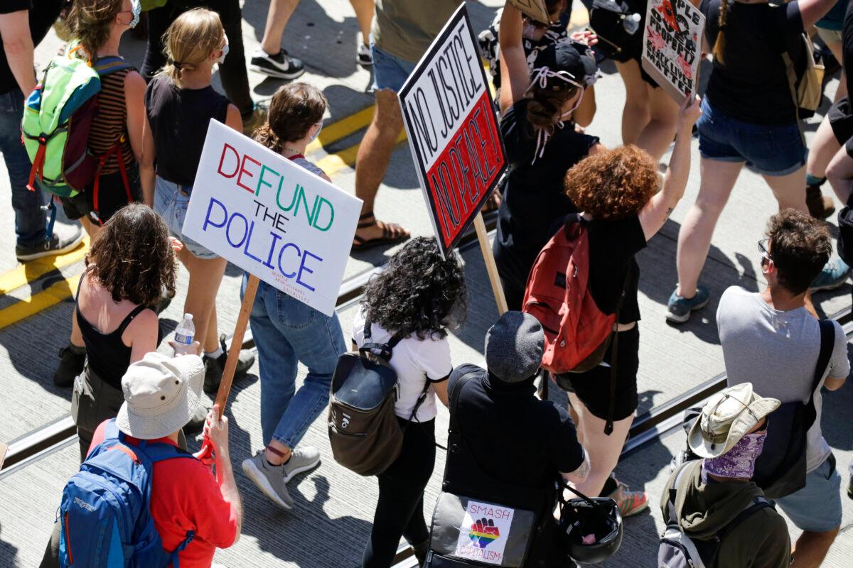 People carry signs during a "Defund the Police" march from King County Youth Jail to City Hall in Seattle, Wash., on Aug 5, 2020. (Jason Redmond/AFP via Getty Images)