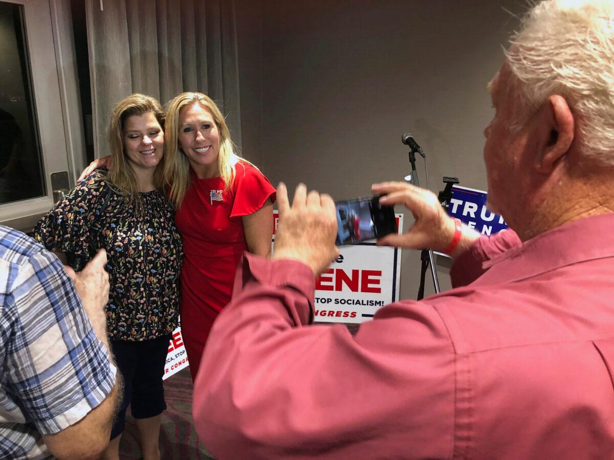 Supporters take photos with Marjorie Taylor Greene, background right, in Rome, Ga., on Aug. 11, 2020. (Mike Stewart/AP Photo)