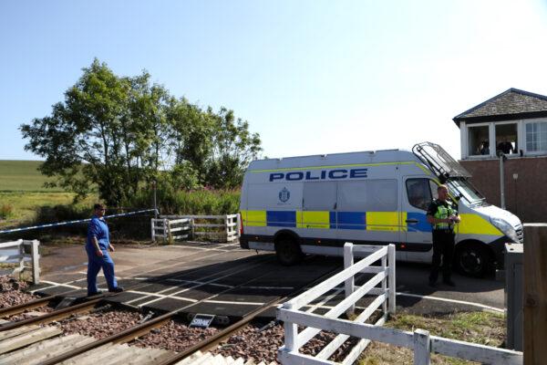 A police vehicle crosses the tracks near the scene of a derailed passenger train, in Carmont, Stonehaven, Scotland, Britain, on Aug. 12, 2020. (Russell Cheyne/Reuters)