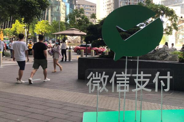 People walk past a Wechat Pay sign at the Tencent company headquarters in Shenzhen, Guangdong province, China, on Aug. 7, 2020. (Reuters/David Kirton)