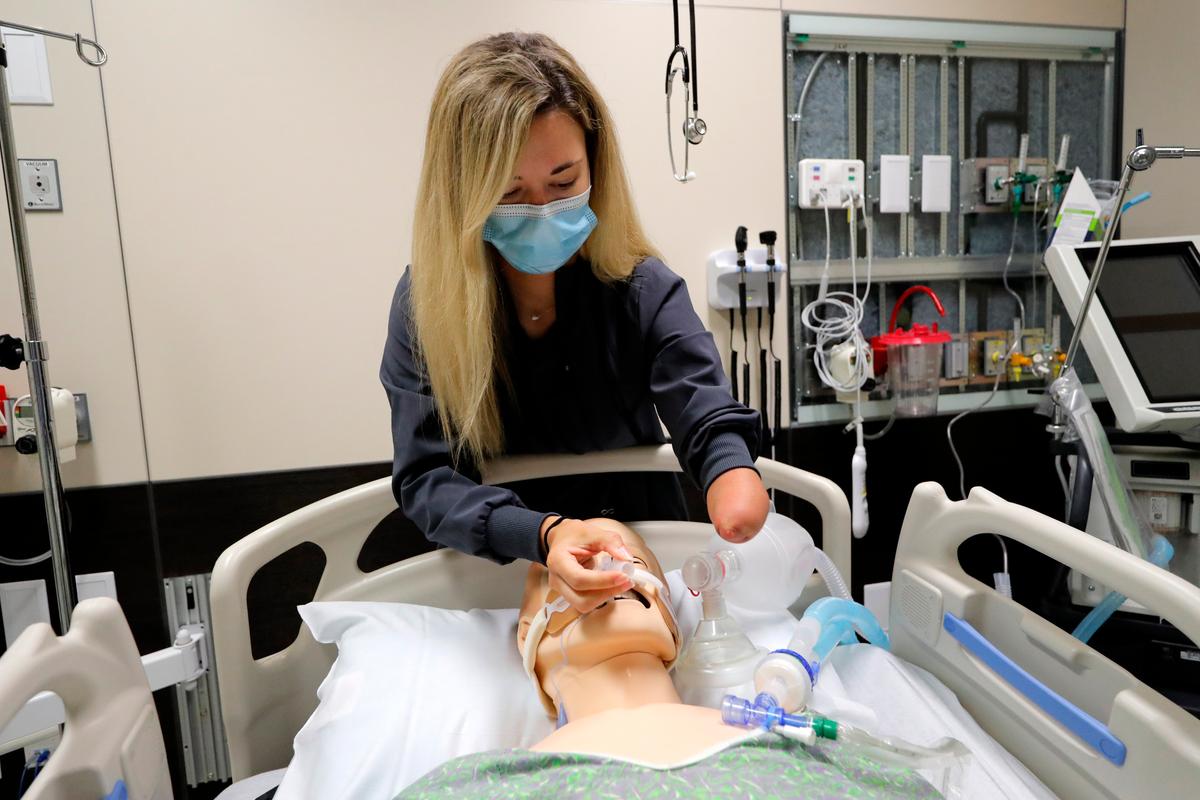 Respiratory therapist Savannah Stuard, who was born without a left forearm, demonstrates her techniques for treating COVID-19 patients at Ochsner Medical Center in New Orleans on July 28, 2020. (Gerald Herbert/AP)