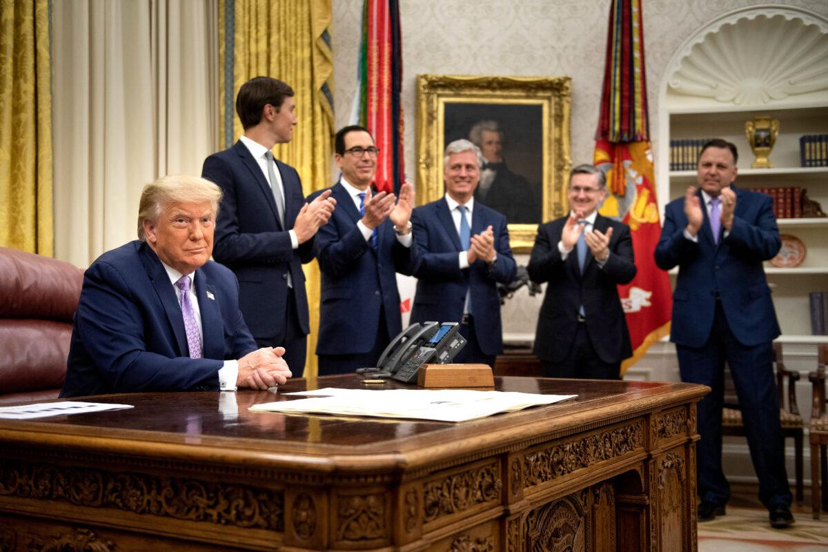(L–R, rear) Senior adviser Jared Kushner, Secretary of the Treasury Steven Mnuchin, national security adviser Robert O'Brien, and others clap for President Donald Trump (L) after he announced an agreement between the United Arab Emirates and Israel to normalize diplomatic ties, at the White House on Aug. 13, 2020. (Brendan Smialowski/AFP via Getty Images)
