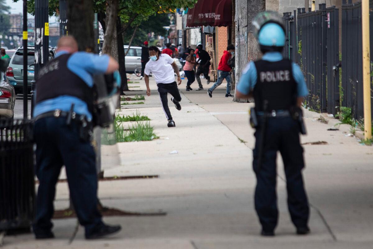 Chicago police officers respond to shots fired near reports of rioting on West Madison Street near South Karlov Avenue on the West Side, of Chicago, Aug. 10, 2020. (Ashlee Rezin Garcia/Chicago Sun-Times via AP)