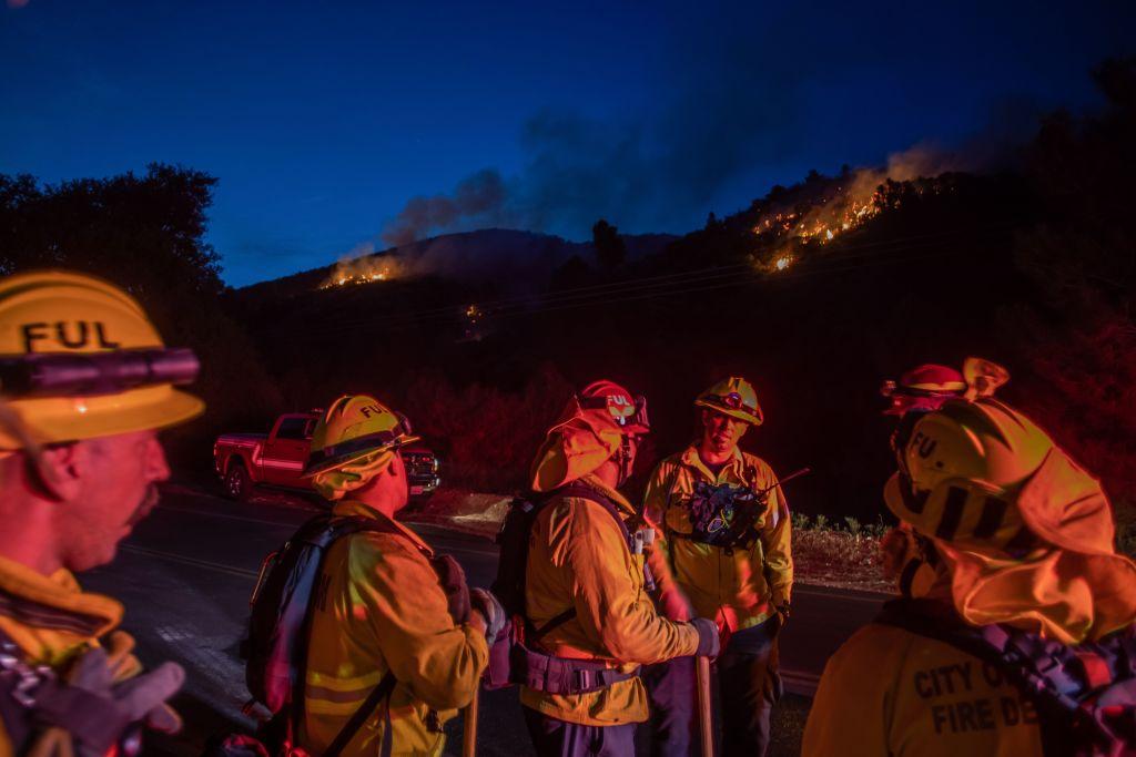 Firefighters work to extinguish hotspots from the Lake Fire at Pine Canyon Road in the Angeles National Forest, by Lake Hughes, 60 miles north of Los Angeles, Calif., on Aug. 13, 2020. (APU GOMES/AFP via Getty Images)