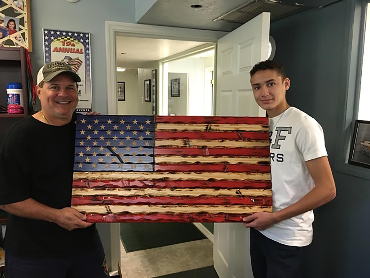 Lorenzo Liberti, 15, with a wooden flag he carved and painted. (Courtesy of Gaetano Liberti)