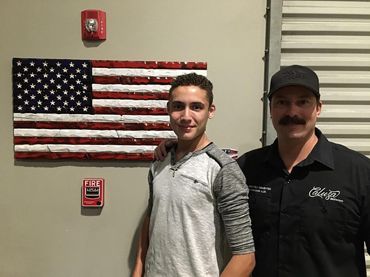 A Navy Seal Veteran who owns Calusa Brewery, son of the auction winner from the "Be The Key" Gala, with Lorenzo Liberti and his flag. (Courtesy of Gaetano Liberti)
