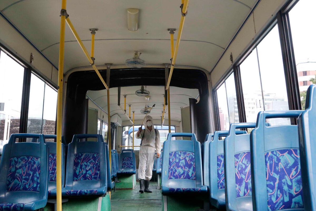 A man in a protective suit disinfects the inside of a trolley bus to help curb the spread of the coronavirus in Pyongyang, North Korea, on Aug. 13, 2020. (Jon Chol Jin/AP Photo)