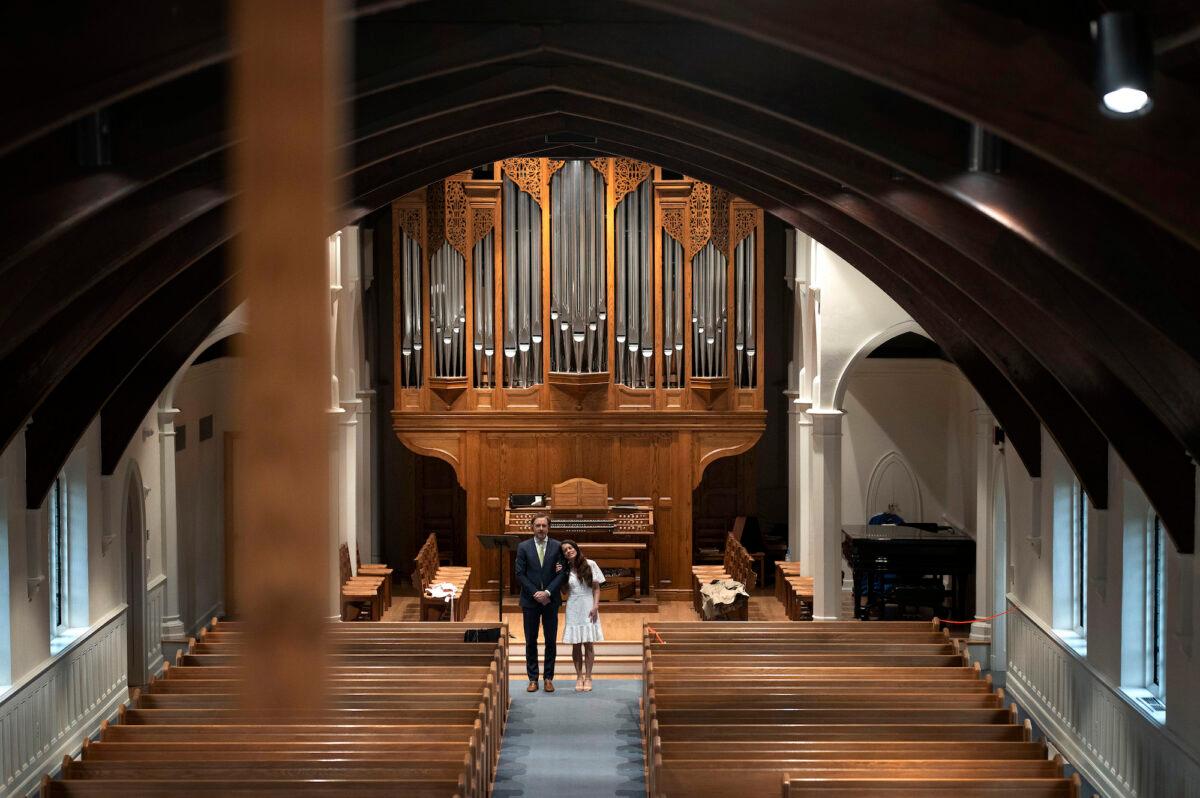 A couple of soon-to-be newlyweds await the start of their marriage ceremony in an otherwise empty church, in Arlington, Va., on April 18, 2020. (Win McNamee/Getty Images)