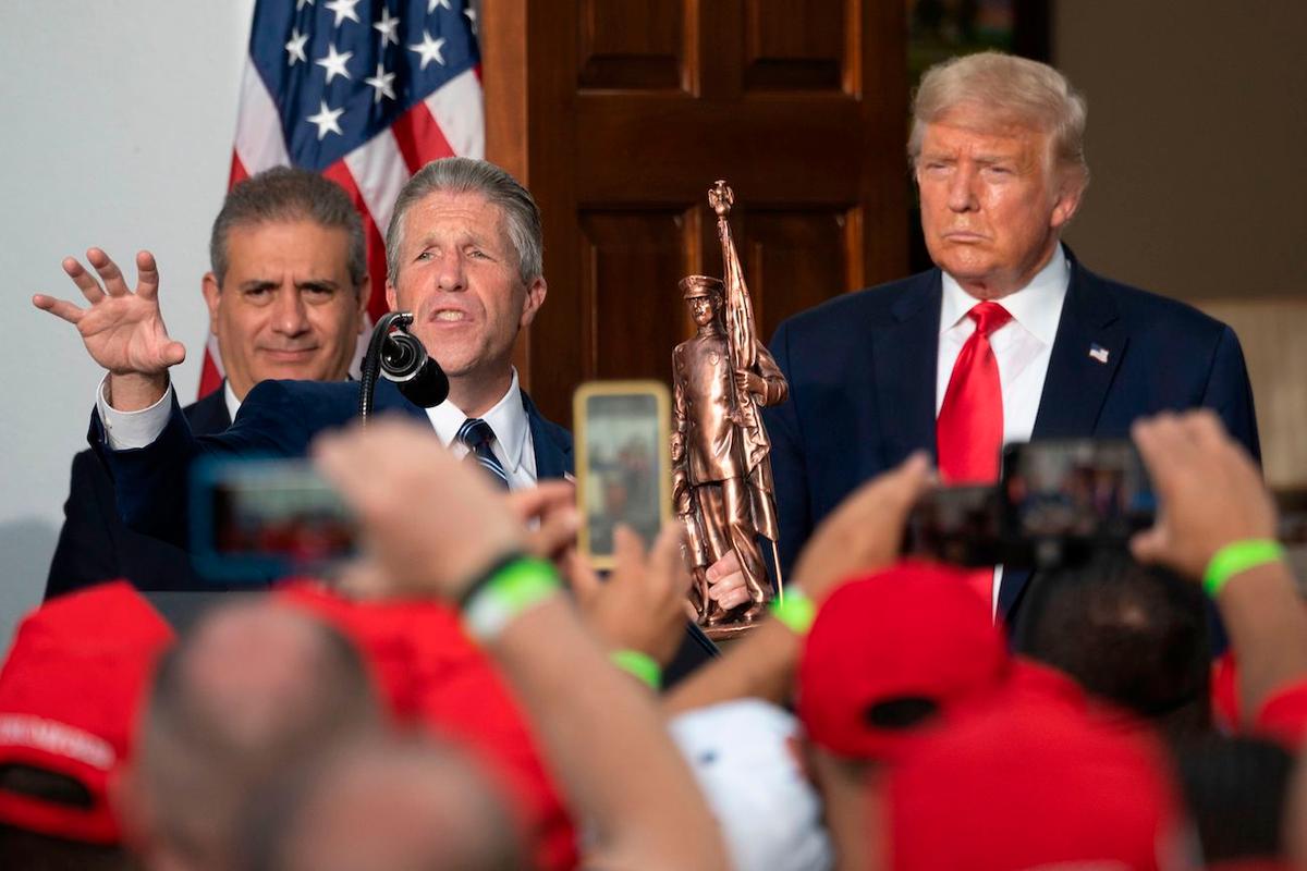 The Police Benevolent Association of the City of New York (PBA) President Patrick Lynch (2nd L) presents President Donald Trump with a statue after the biggest police union in the United States announced the endorsement of Trump's re-election in Trump National Golf Club in Bedminster, N.J., on Aug. 14, 2020. (Jim Watson/AFP via Getty Images)