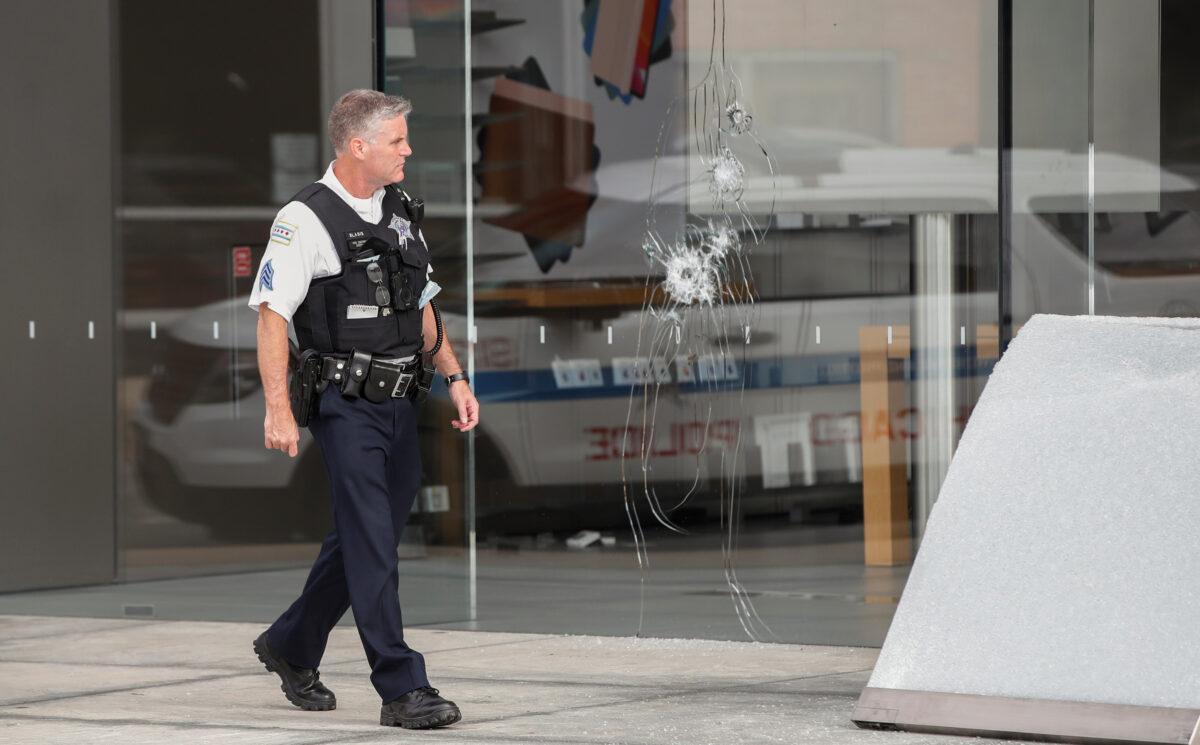 A Chicago police officer inspects an Apple store that was vandalized in Chicago on Aug. 10, 2020. (Kamil Krzaczynski/Reuters)