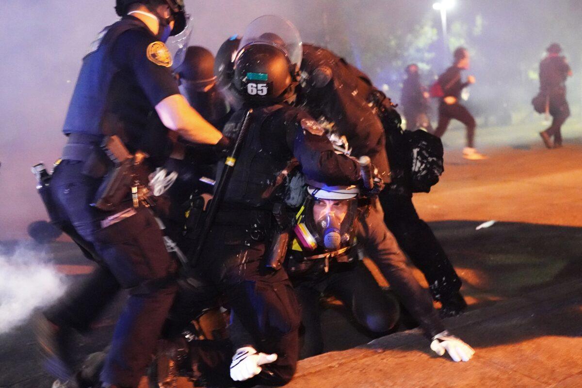 Portland police officers arrest a man amid rioting in Portland, Ore., on Aug. 14, 2020. (Nathan Howard/Getty Images)