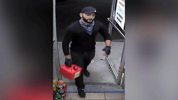 A man identified by authorities as Sam Resto, 29, on surveillance video holding a red jerry can at a gas station located in Elmhurst, New York, on July 28, 2020. (U.S. District Court, Eastern District of New York)