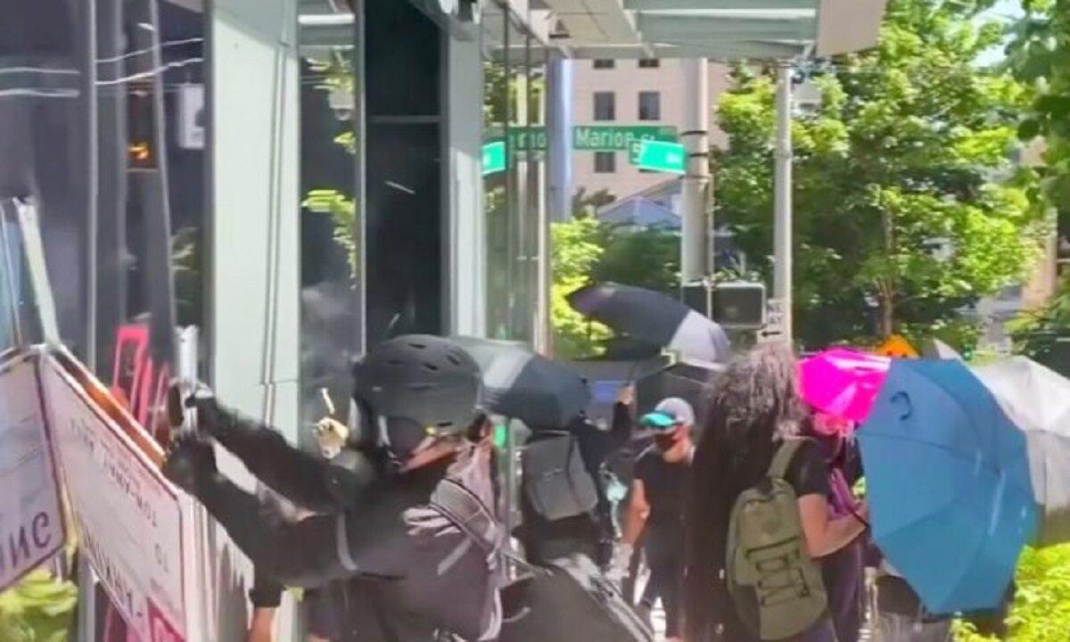  Rioters try to break into an Amazon store in Seattle in a July 19, 2020, file photograph. (Katie Daviscourt via Reuters)
