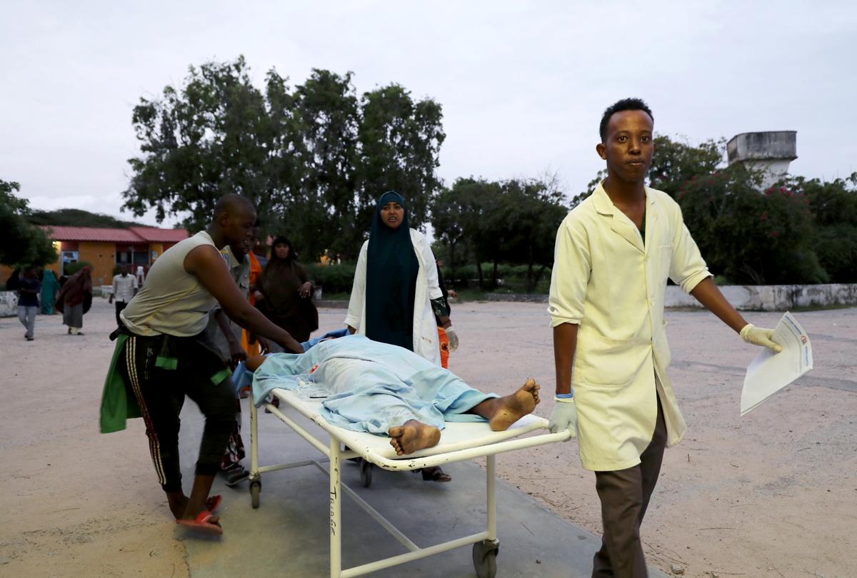 Paramedics and civilians carry an injured person on a stretcher at Madina hospital after a blast at the Elite Hotel in Lido beach in Mogadishu, Somalia, on  Aug. 16, 2020. (Reuters/Feisal Omar)
