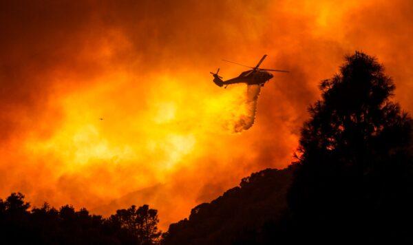 A helicopter drops water on the Lake Hughes Fire in Angeles National Forest north of Santa Clarita, Calif., on Aug. 12, 2020. (Ringo H.W. Chiu/AP Photo)