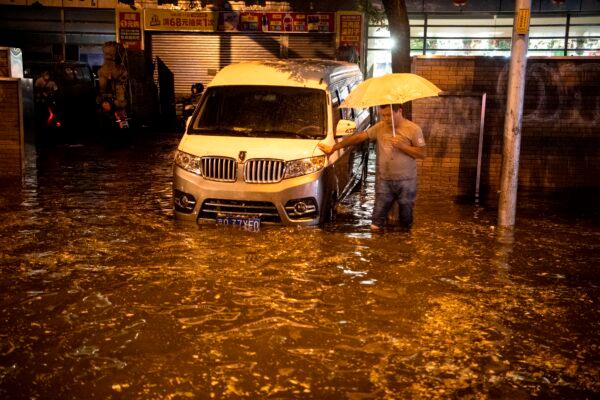 A man looks at a flooded street after a sudden rain in Beijing on Aug. 9, 2020. (NOEL CELIS/AFP via Getty Images)