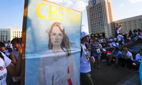 People carry a portrait of Sviatlana Tsikhanouskaya, former candidate for the presidential elections during opposition rally in front of the government building in Minsk on Aug. 17, 2020. (Sergei Grits/AP Photo)