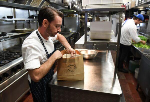 (Illustration purposes only) Chef packs a takeaway meal in the kitchen of French restaurant France-Soir in Melbourne on May 8, 2020. (William West/AFP via Getty Images)