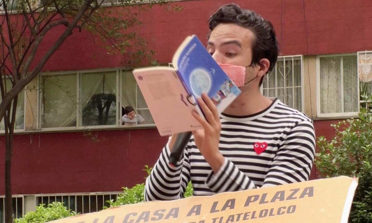 Percibald Garcia, 27, reads storybooks aloud outside an apartment in Mexico. (Screenshot/REUTERS)